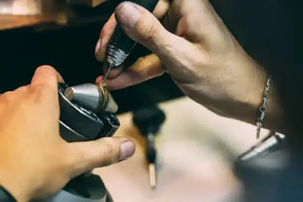Jewellery setter using handpiece under microscope for precision stone setting