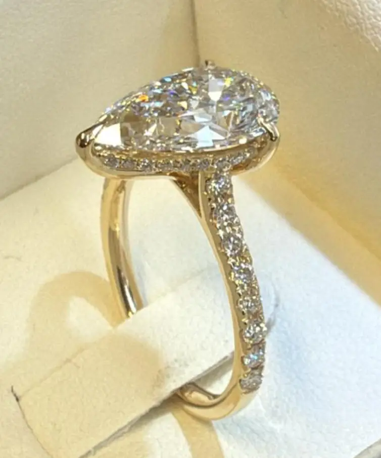 Oval diamond halo ring in yellow gold with micro pavé setting completed